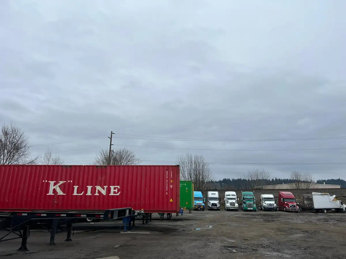 D&G Transport yard with parked tractors and stacked ocean containers