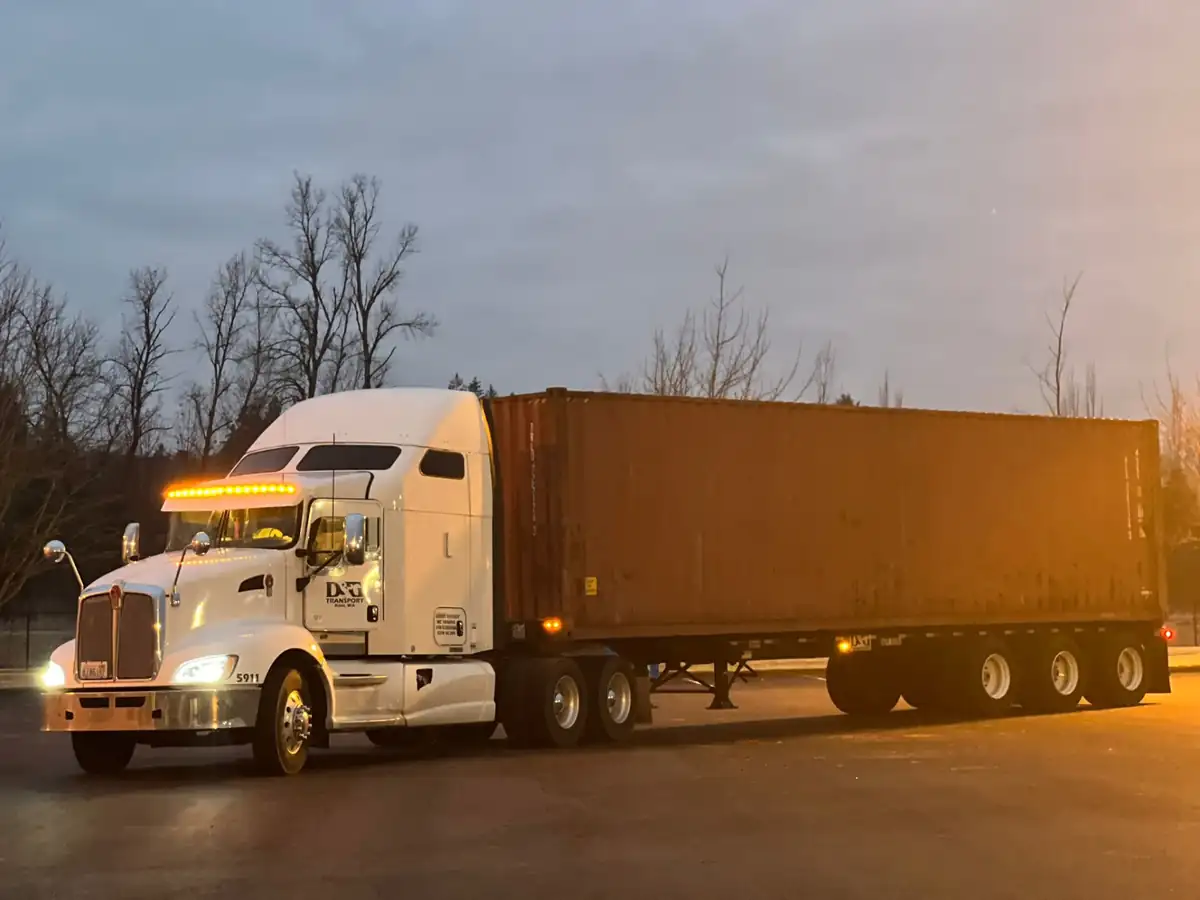 D&G Transport Kenworth pulling a loaded 40ft container out of the yard at dawn